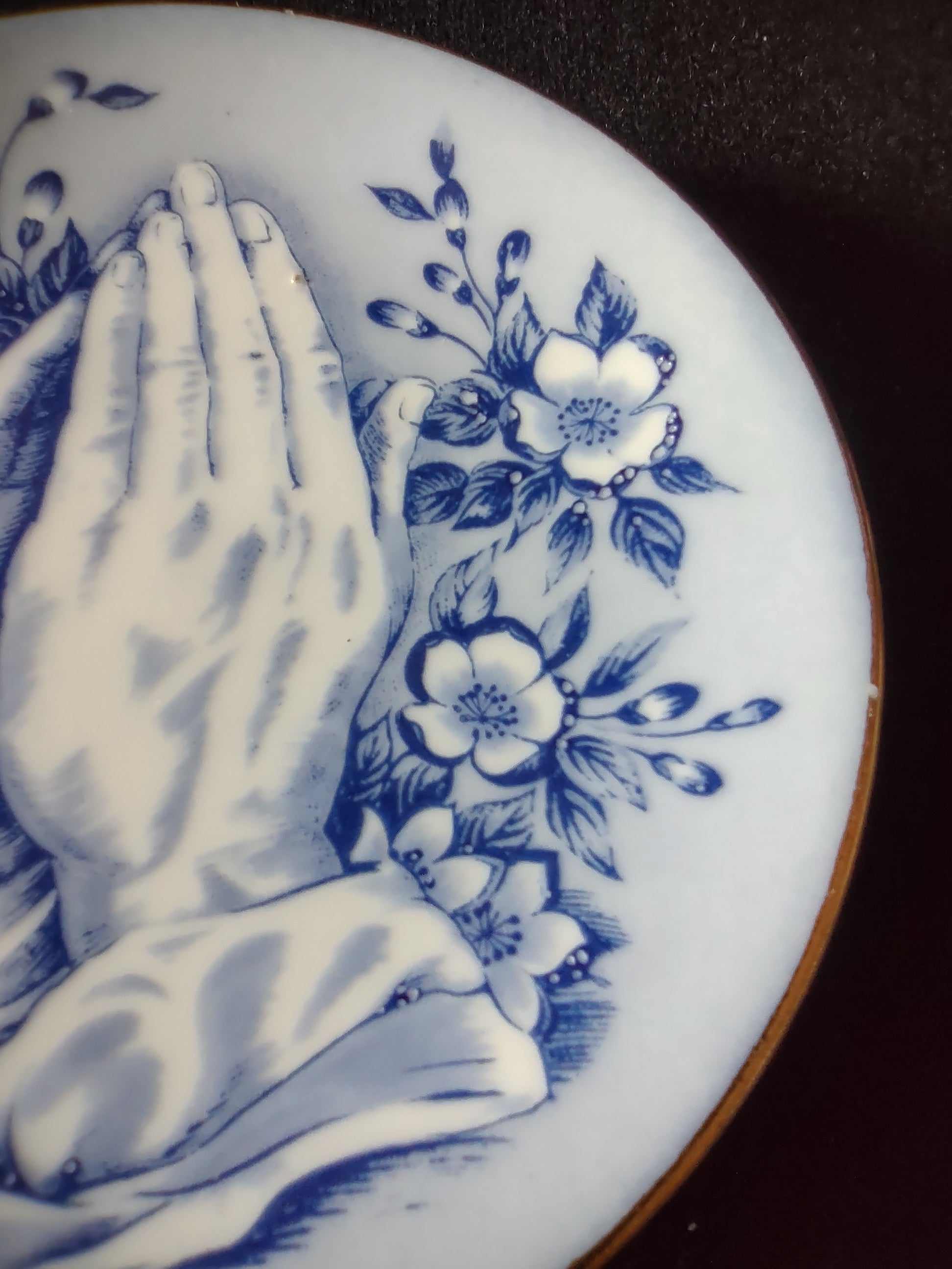 Vintage blue white praying hands plate close-up rim and floral spray detail