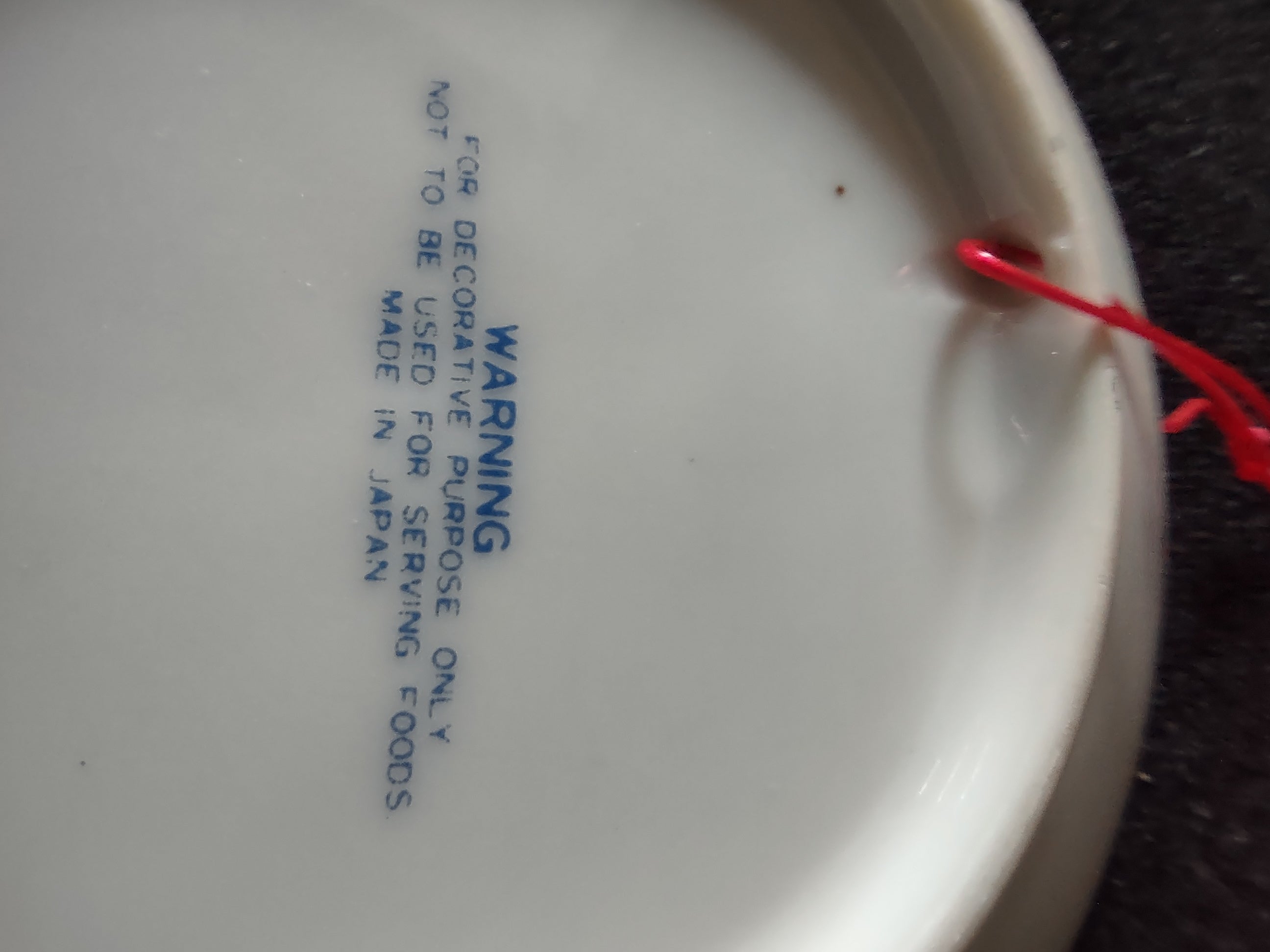 Vintage blue white praying hands plate with ruler showing 4 inch diameter