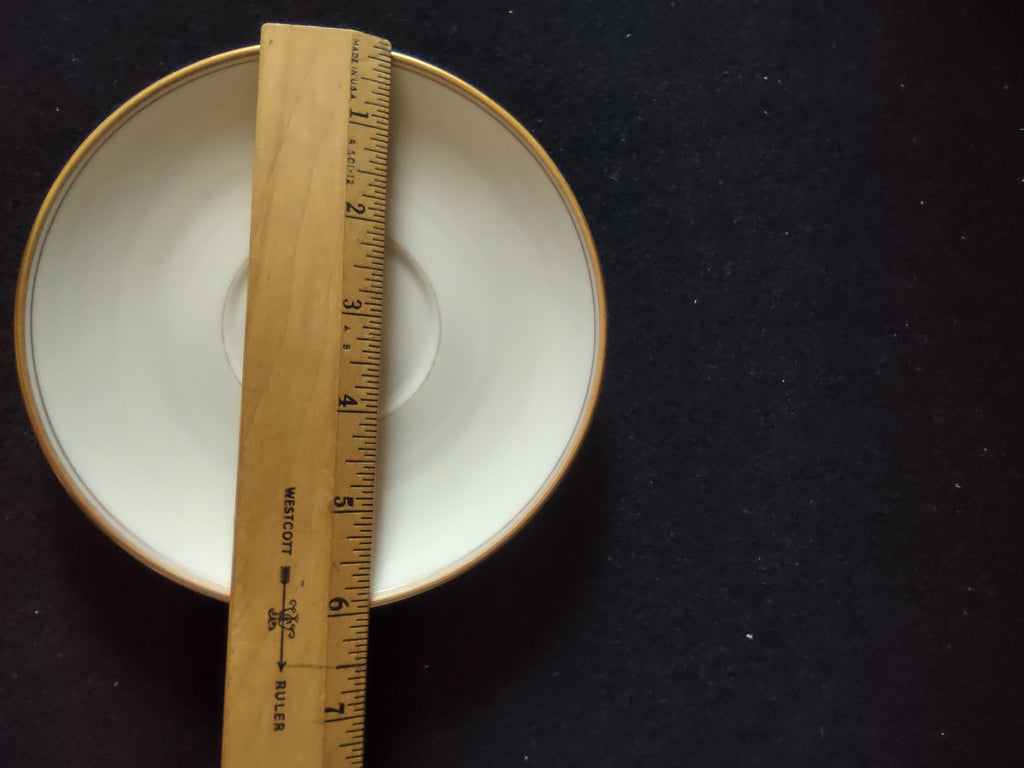 Franciscan China saucer with ruler showing approximately 5.5 inch diameter