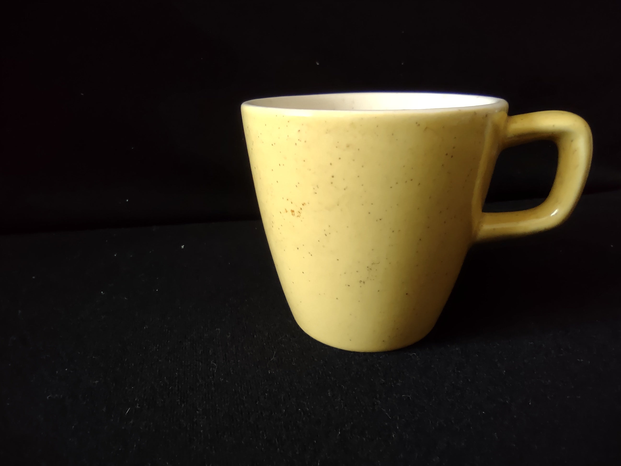 Vintage yellow speckled stoneware coffee cup front view