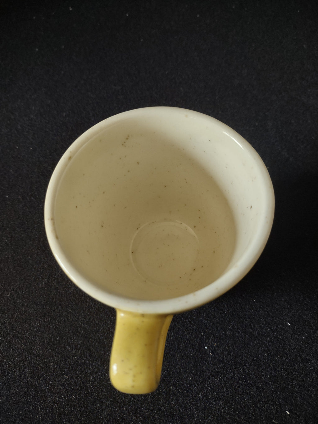 Vintage yellow speckled stoneware coffee cup base showing kiln spur marks