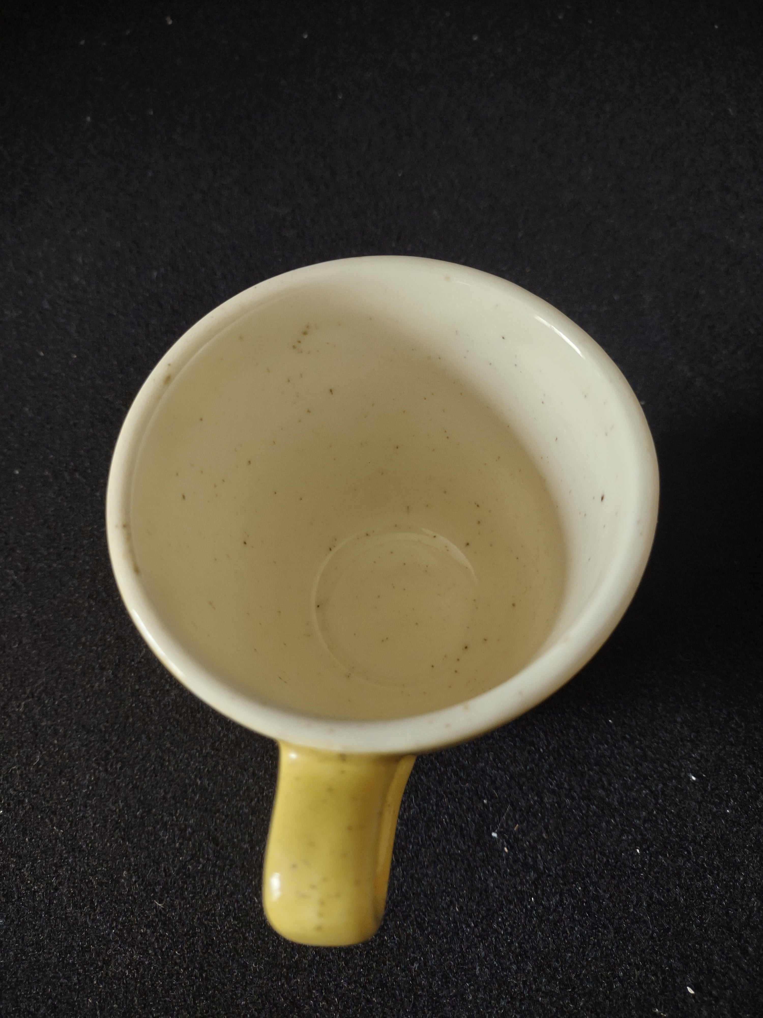 Vintage yellow speckled stoneware coffee cup base showing kiln spur marks