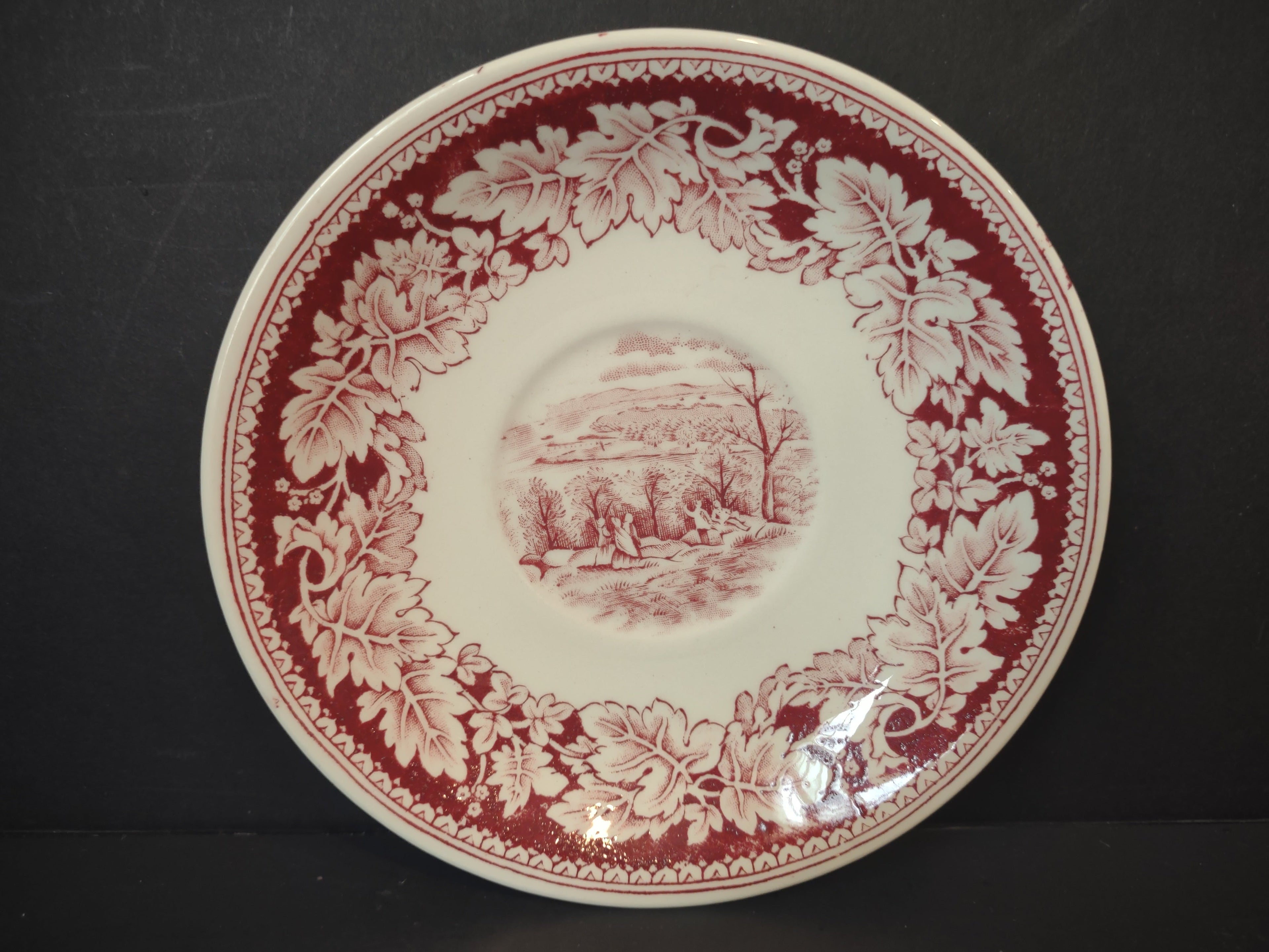 Side measurement view of Vintage Homer Laughlin Currier & Ives red transferware saucer showing approximately 6 inch diameter