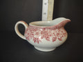 Side view of Vintage red transferware gravy boat creamer with cranberry rose garland pattern and loop handle
