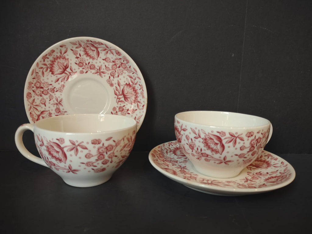 Two Vintage Syracuse China Carefree Mayflower pink floral cup and saucer sets displayed together showing all-over cranberry floral pattern