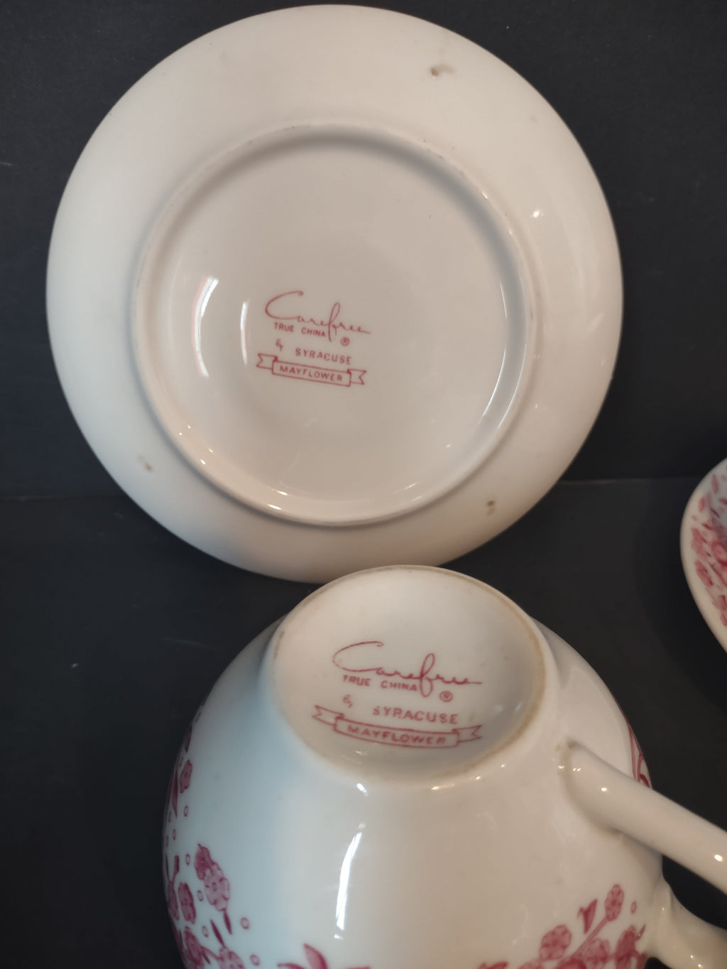 Backstamps of Vintage Syracuse China Carefree True China Mayflower pattern on saucer and cup base in cranberry pink