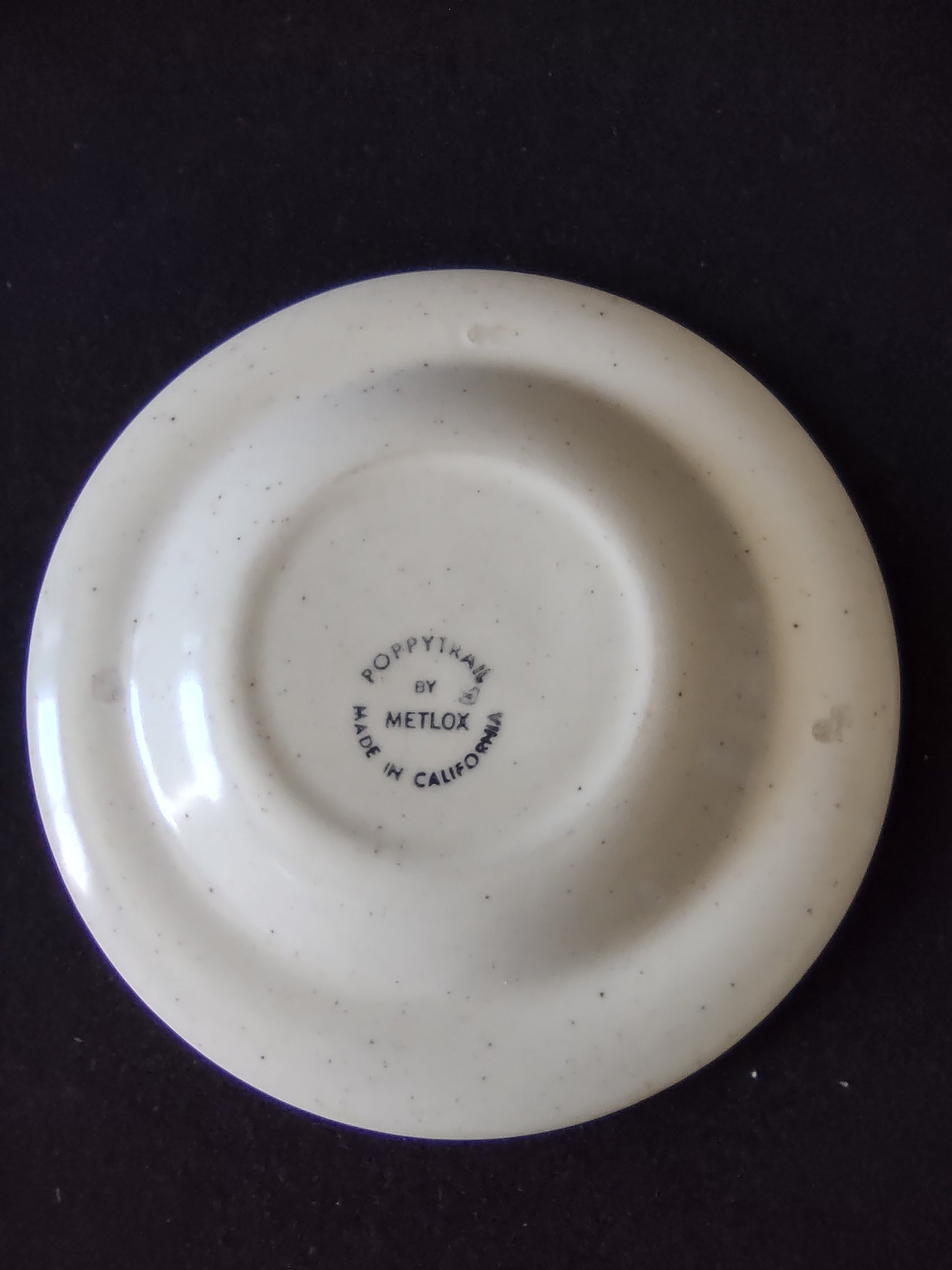 Detail of Metlox Poppytrail Navajo saucer rim showing orange red medallions and brown dot accents