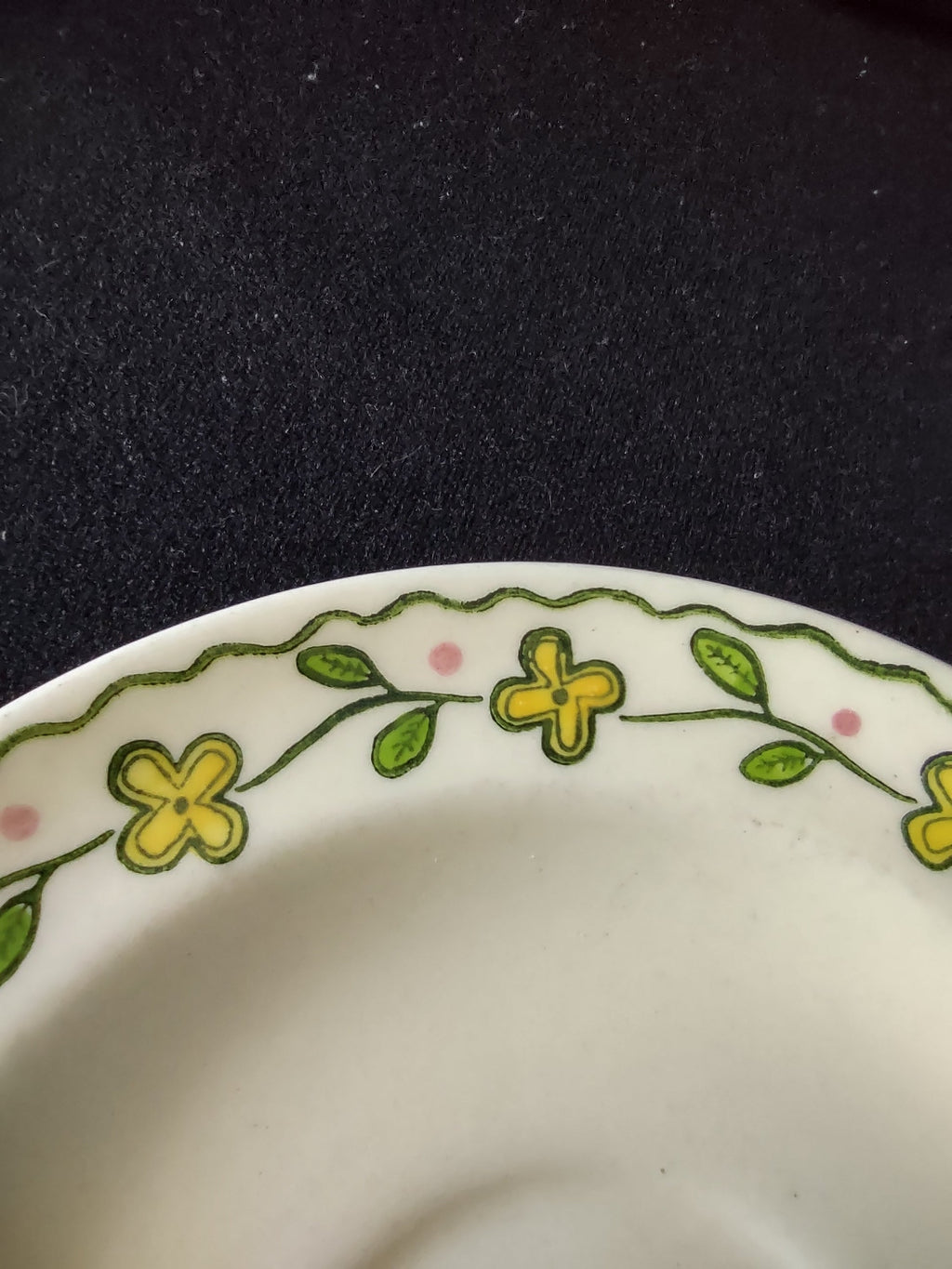 Detail of Watt Pottery Happy Time yellow floral and green leaf pattern on saucer