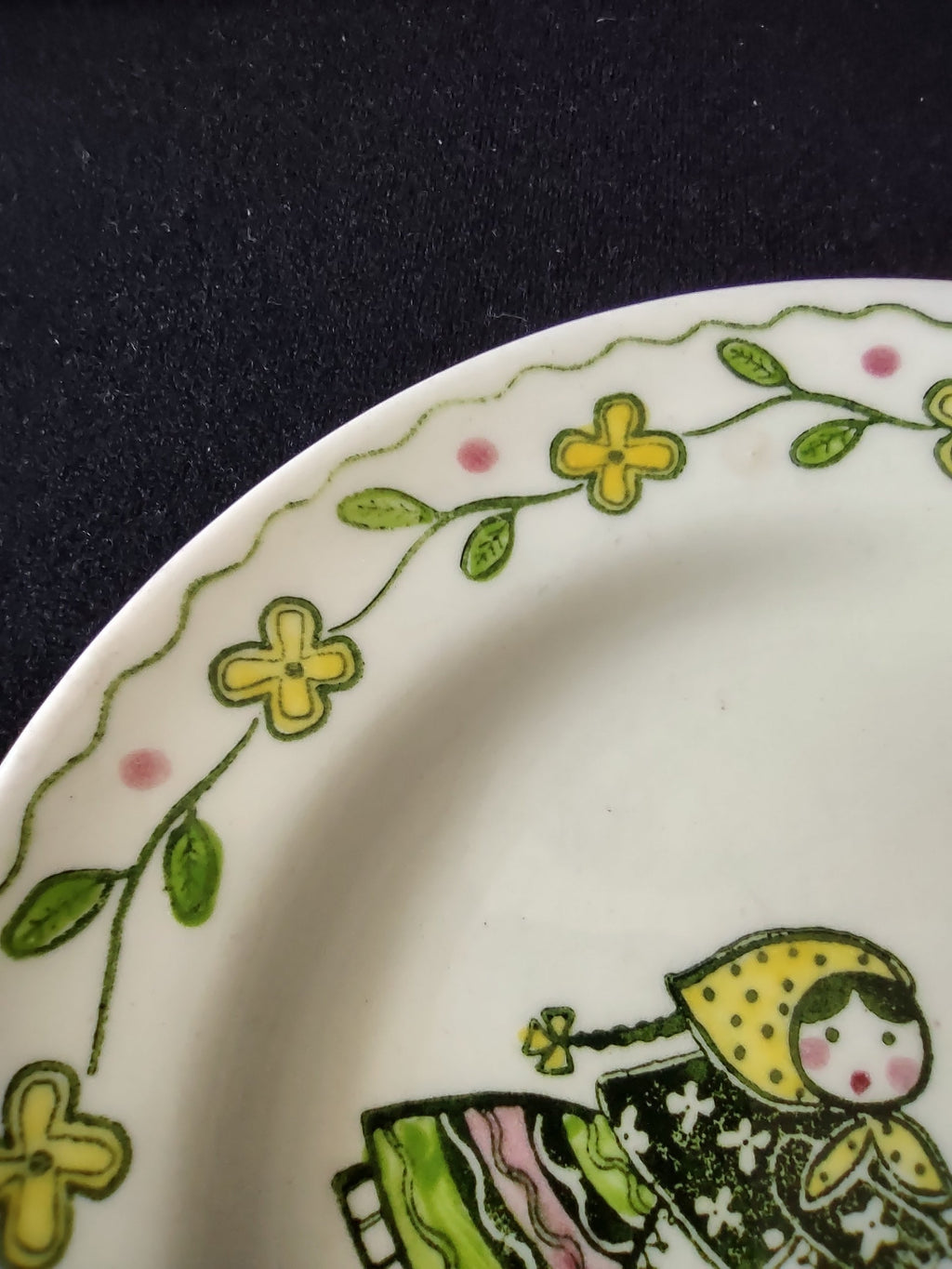 Close-up of Metlox Poppytrail Happy Time saucer rim showing yellow floral and green vine border