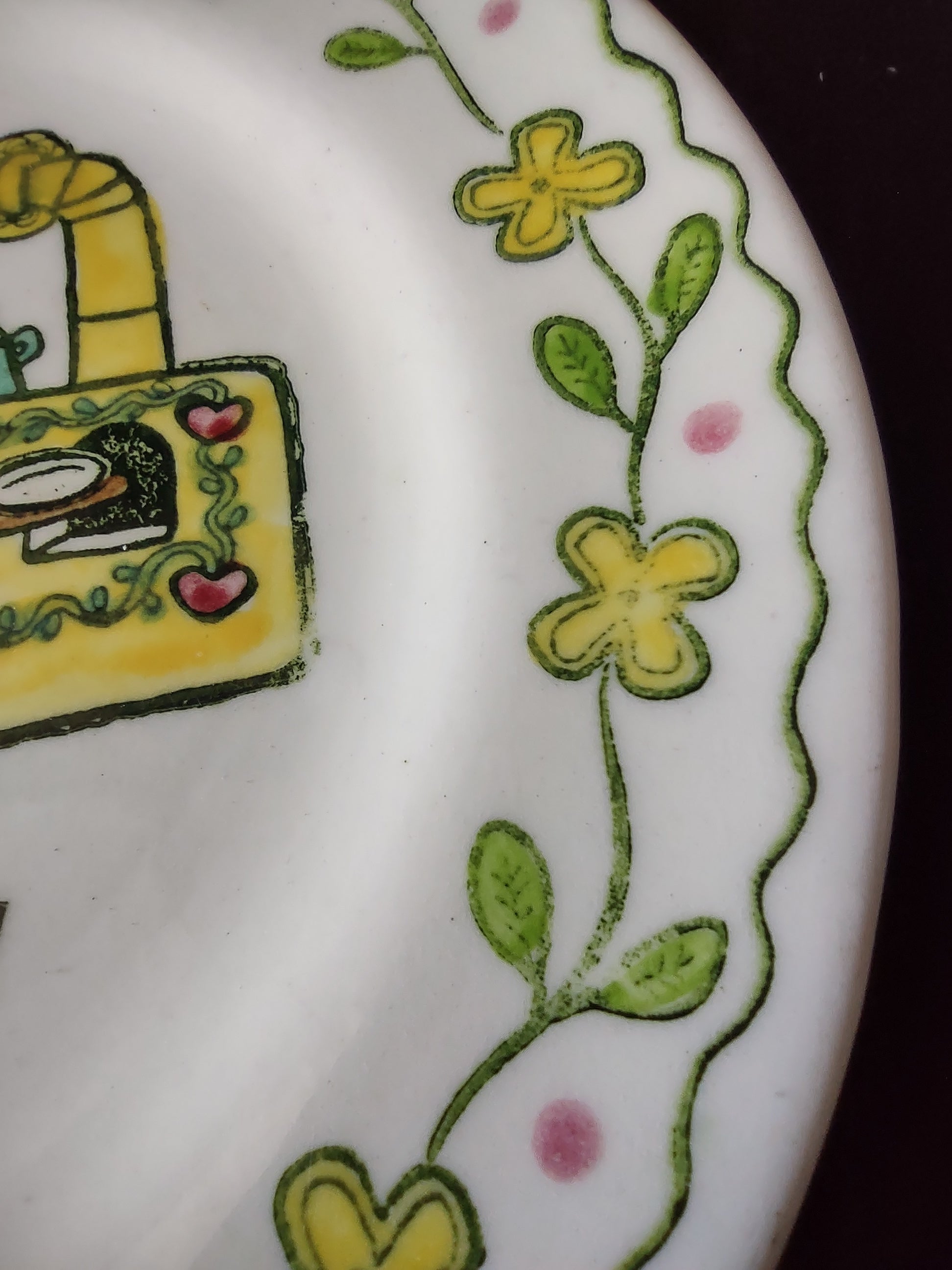 Close-up of Metlox Poppytrail Happy Time saucer showing yellow flowers and green leaf vine border detail