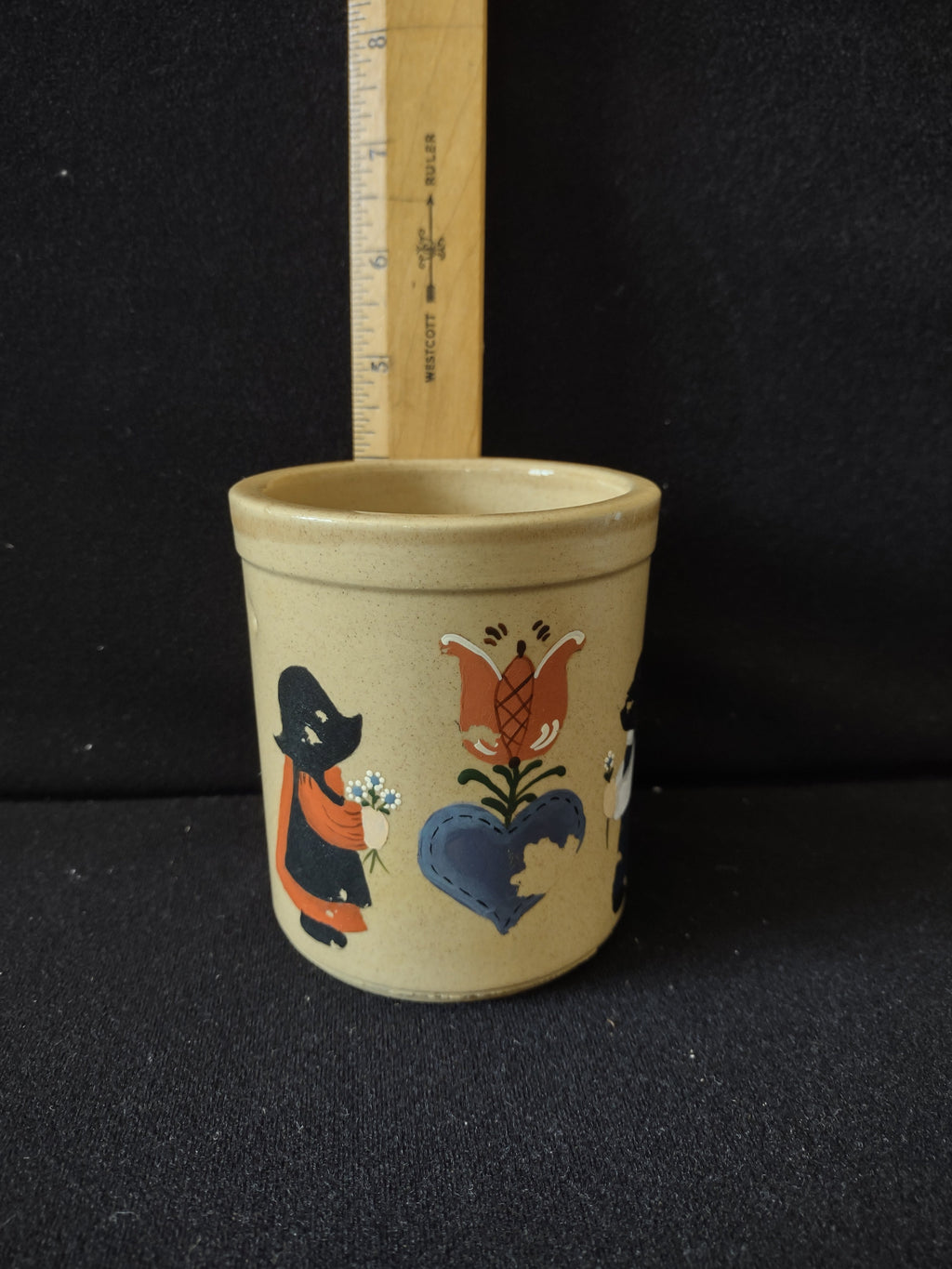 Back view of vintage stoneware crock showing plain tan speckled body