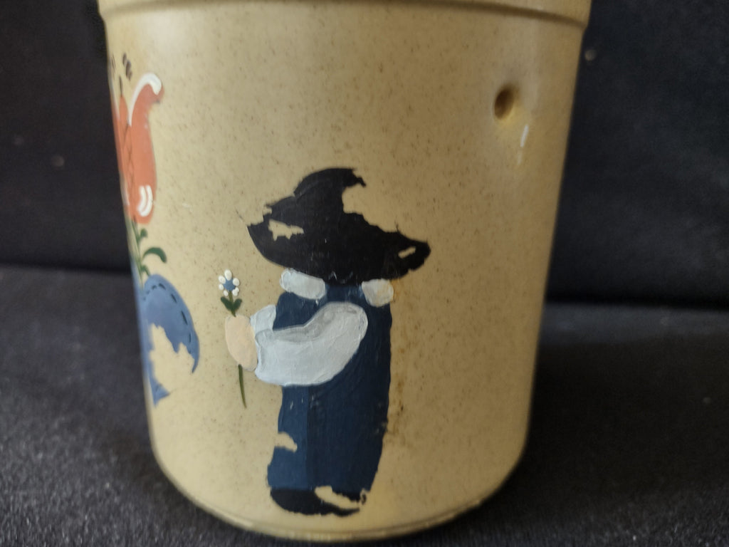 Vintage stoneware crock side view showing Dutch child figure with paint loss on black hat