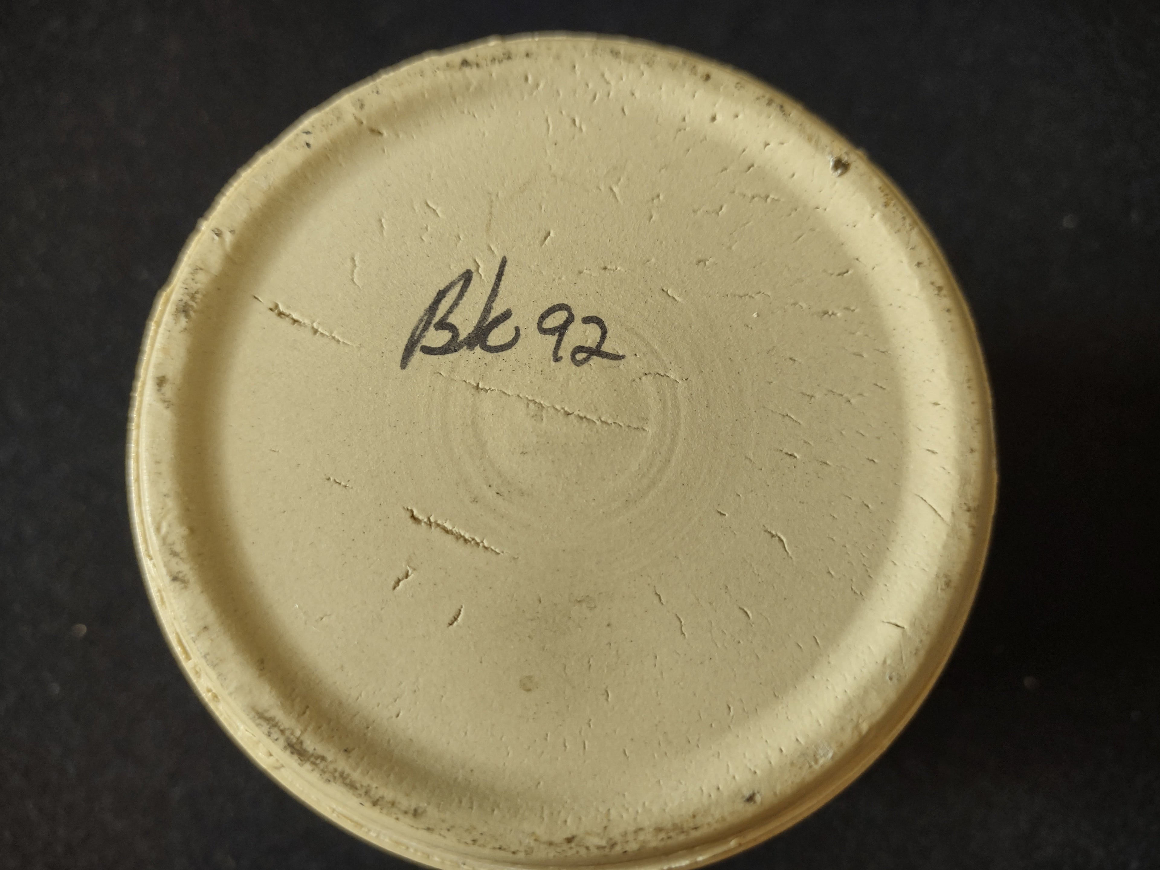 Vintage stoneware crock close-up of Dutch child figure in blue clothing with flower