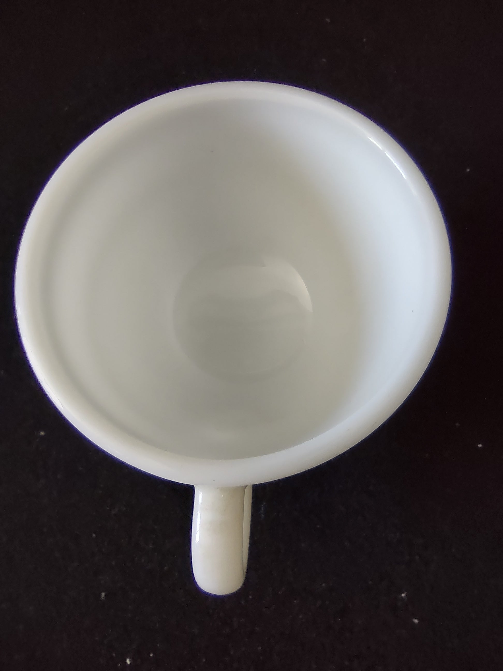 Side view of vintage Buffalo China white milk glass green stripe diner cup with ruler