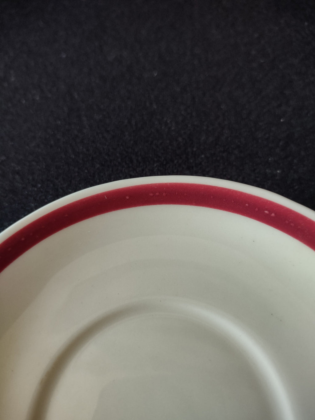 Close-up of burgundy stripe rim on Jackson China Waldhorn saucer showing age-appropriate pitting