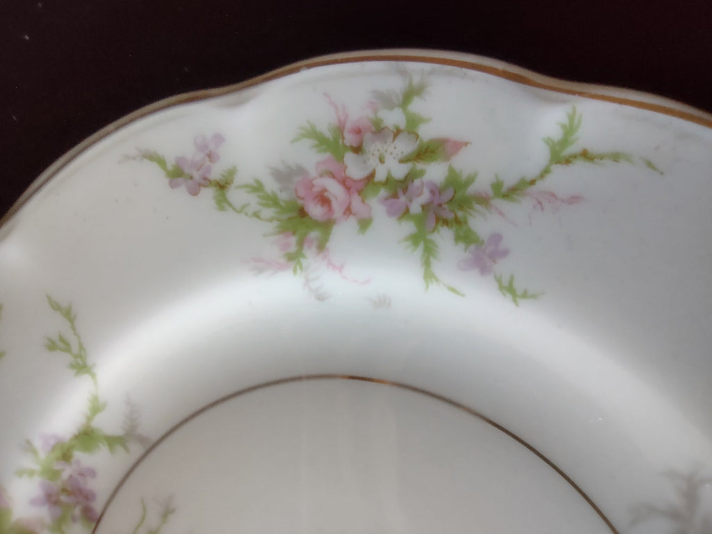 Close-up of pink and lavender floral spray on Haviland Rosalinde plate rim
