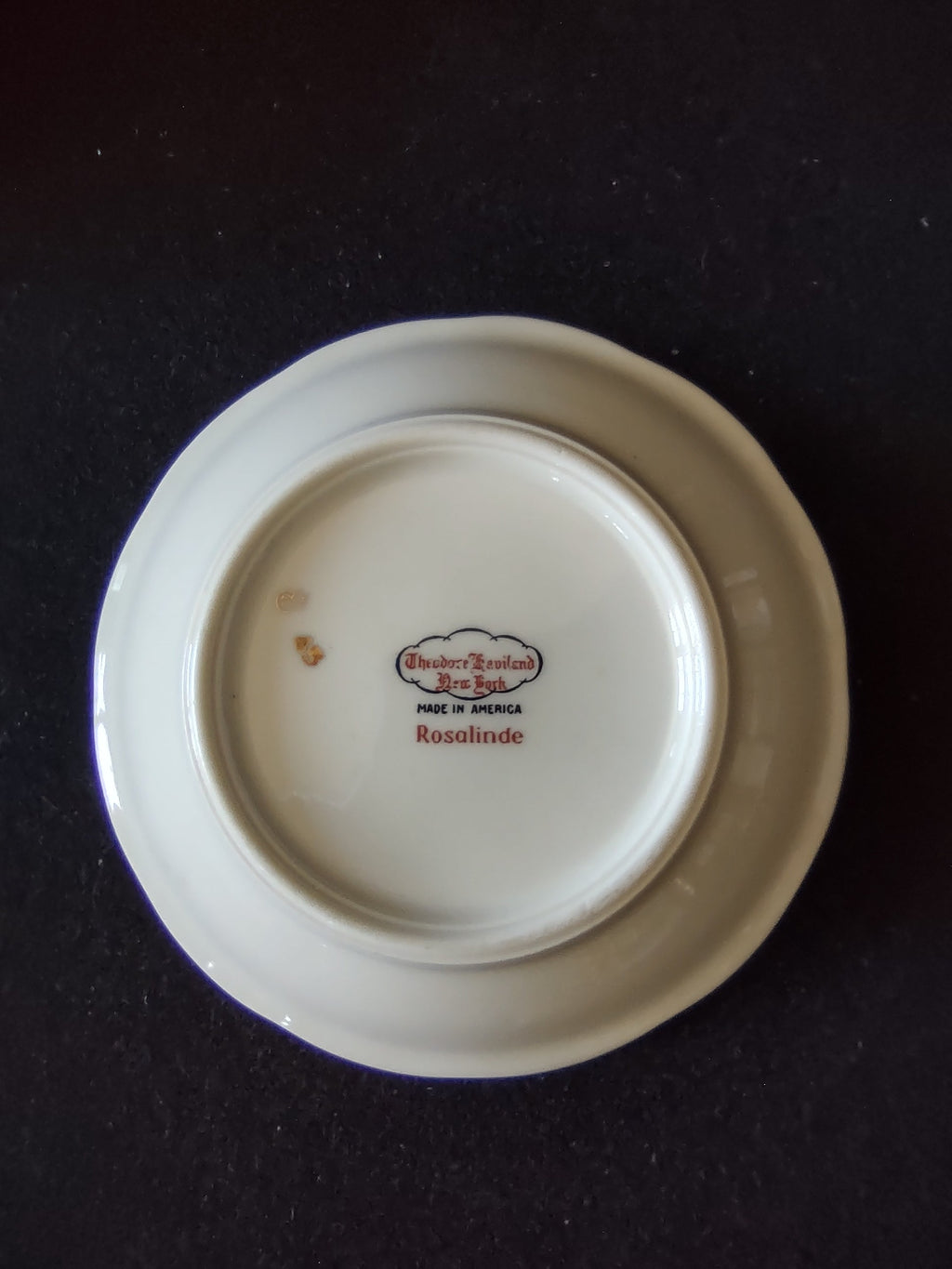 Close-up of pink rose and white blossom spray on Haviland Rosalinde bowl