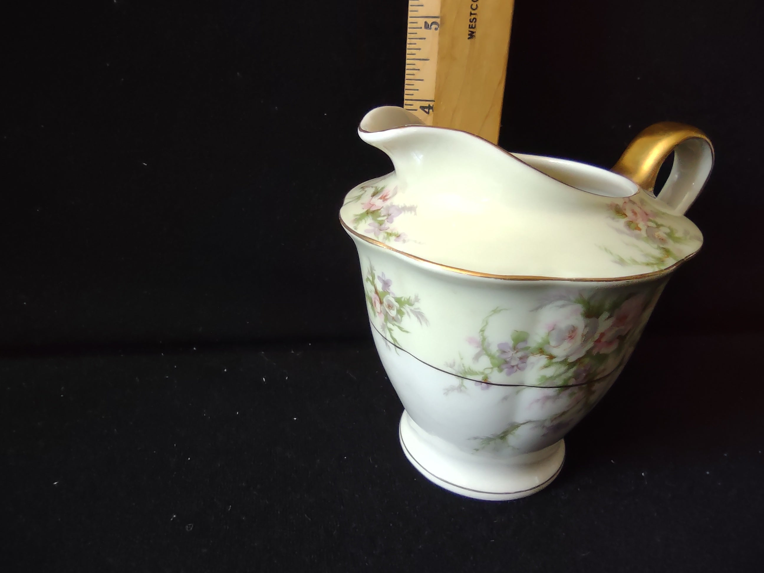 Top-down view of Theodore Haviland Rosalinde creamer interior showing hairline crack