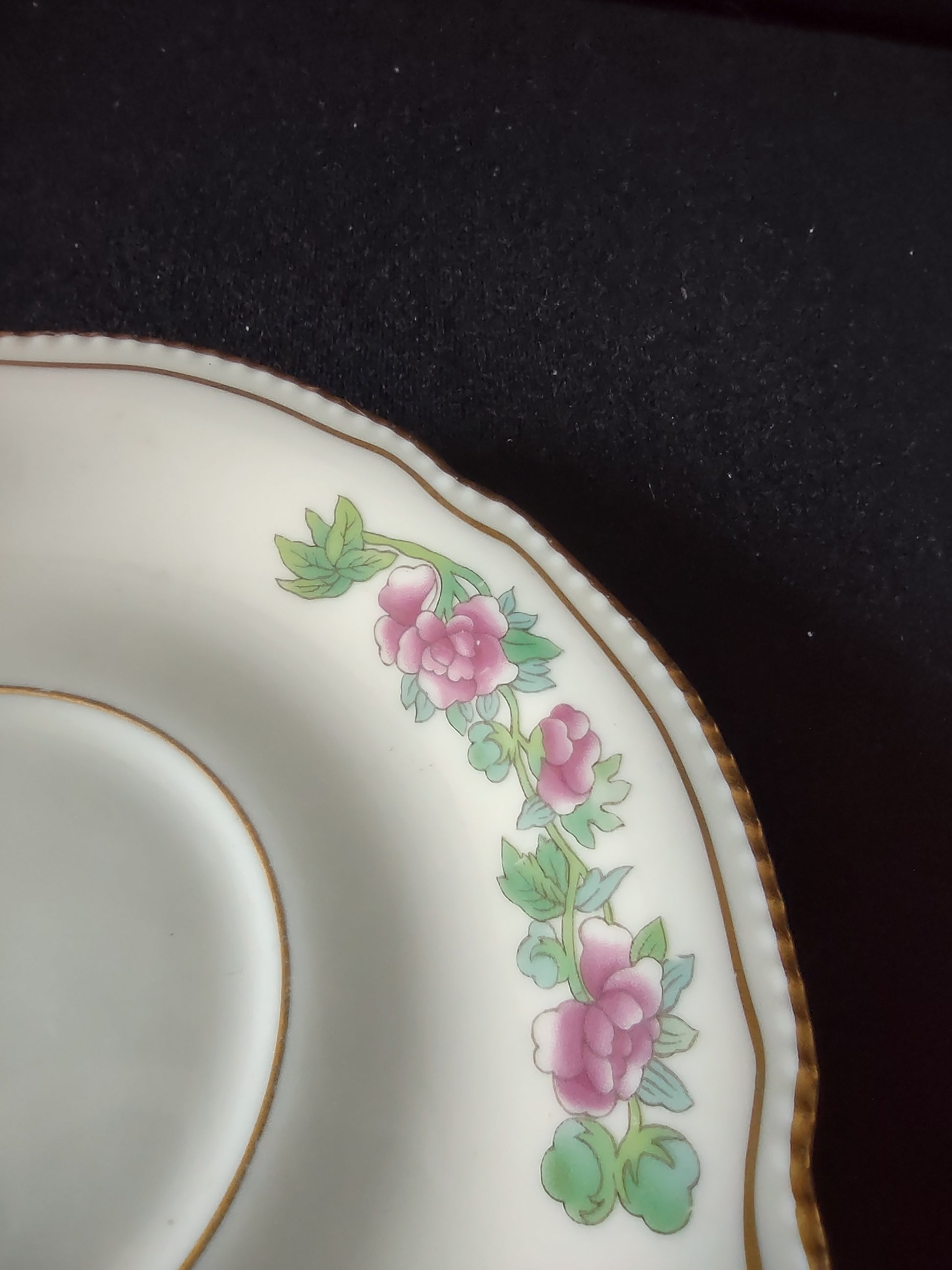 Pink rose and green leaf garland detail on saucer