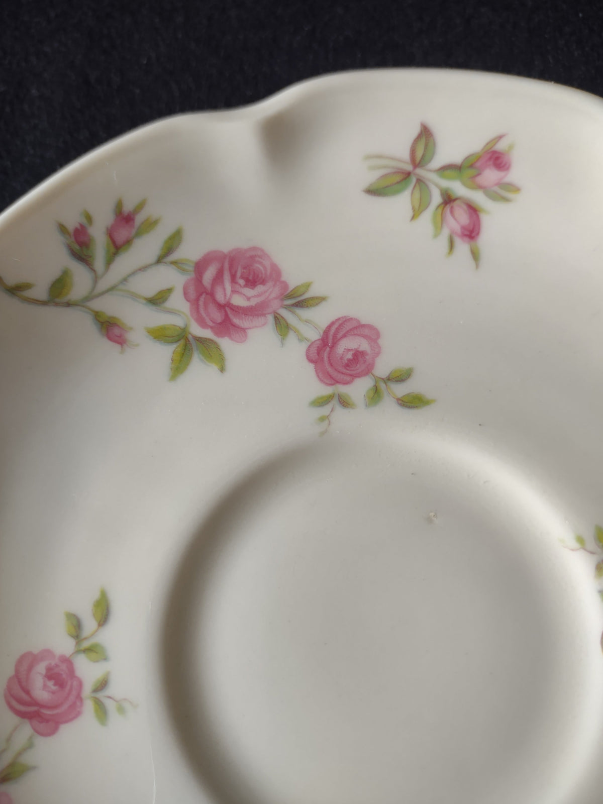 Theodore Haviland Delaware saucer with pink roses and scalloped edge, partial view