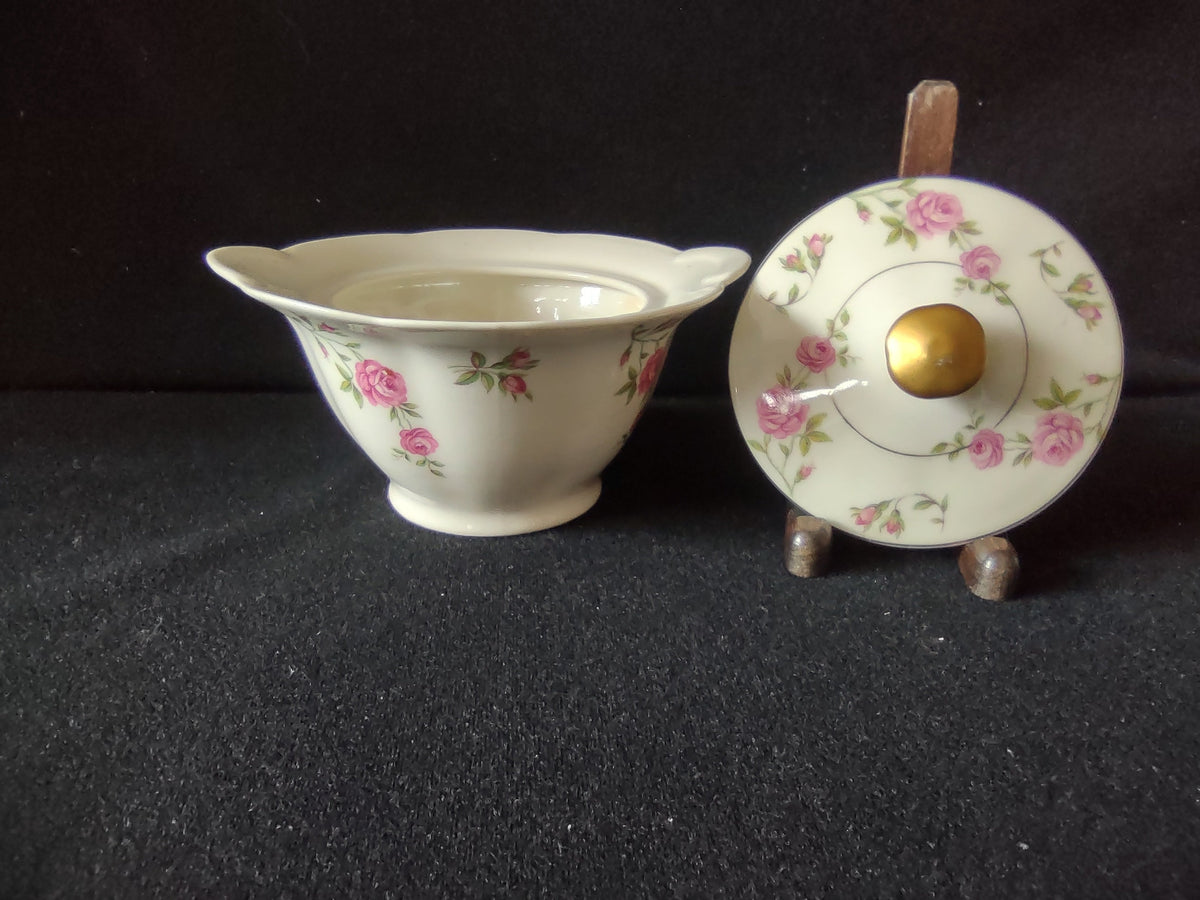 Side profile of sugar bowl showing scattered pink rose pattern and flared form