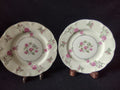 Top view of Theodore Haviland Delaware plate showing central pink rose spray within gold ring, scattered pink rosebuds and roses on rim, scalloped edge