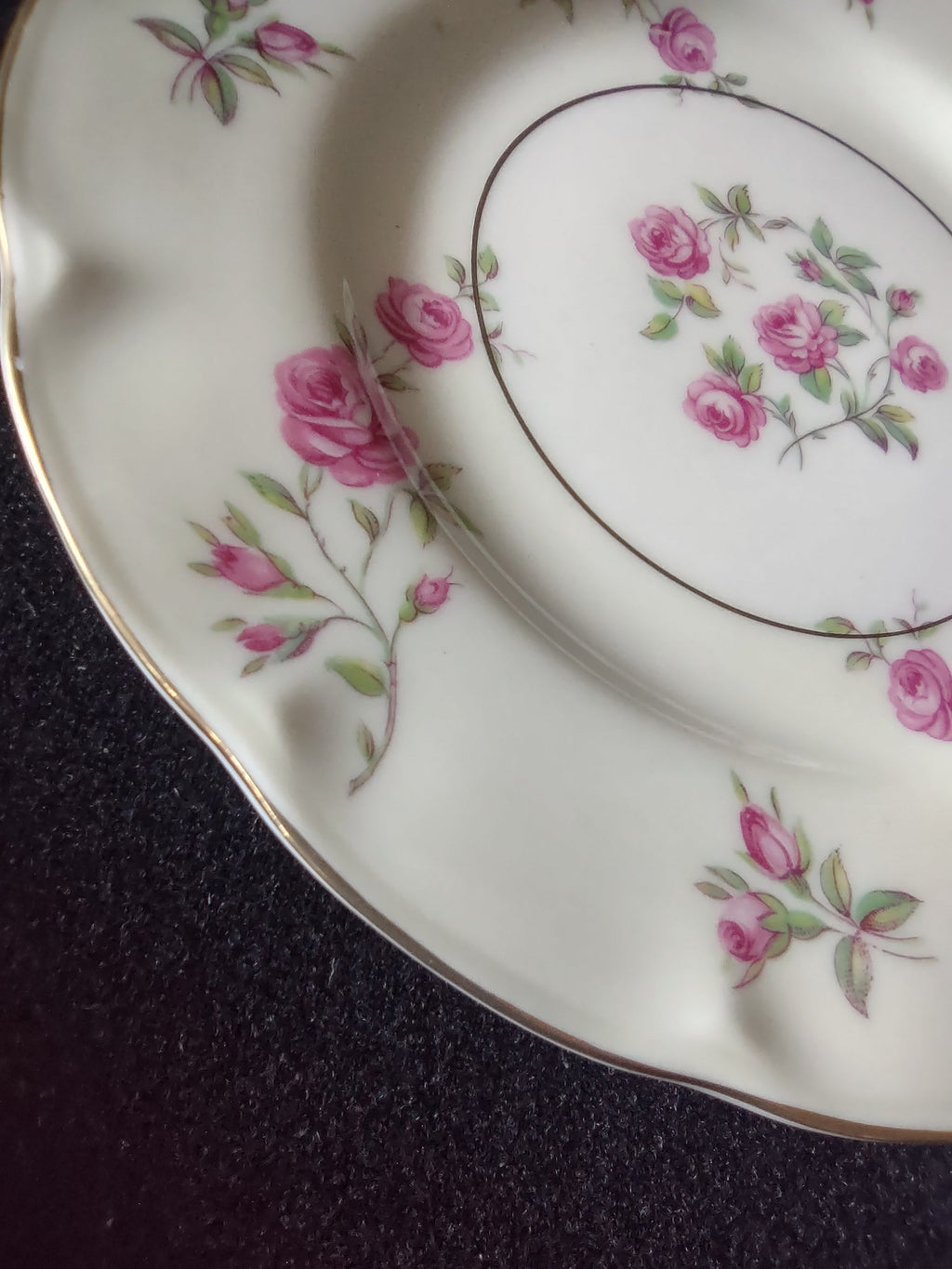 Both Theodore Haviland Delaware plates displayed side by side on wooden plate stands showing matching pink rose pattern and scalloped edges