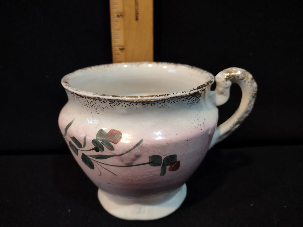 Antique pink lavender lustre ware tea cup with hand-painted green leaves and red berries, silver speckled rim, scrolled handle, approximately 3 inches tall