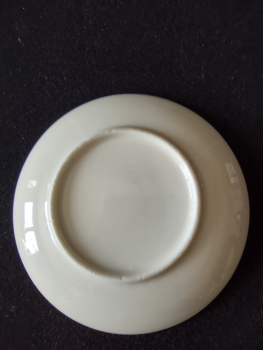 Castleton China butter pat with ruler showing approximately 3.5 inch diameter