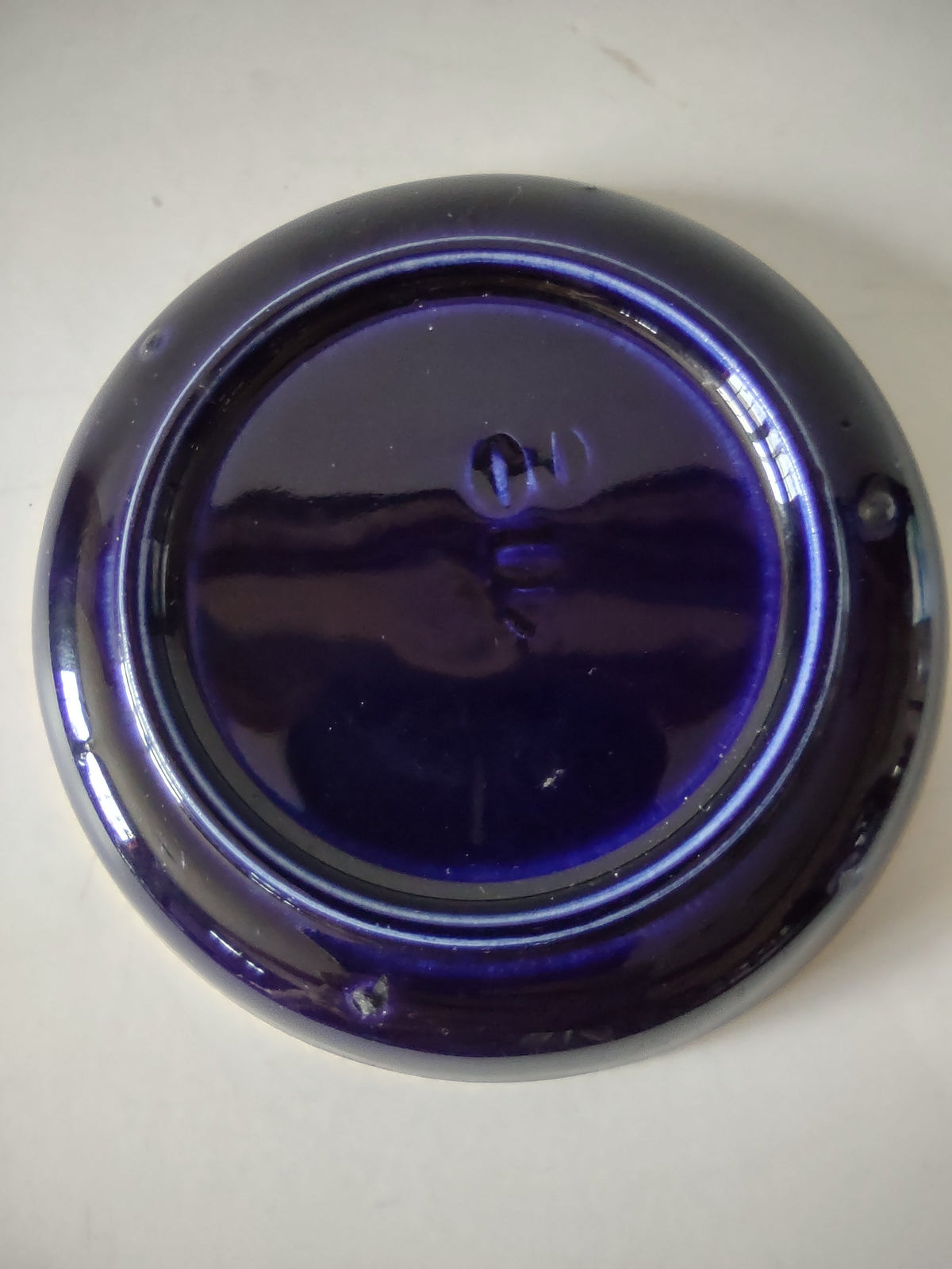 Close-up of cobalt blue saucer rim showing gold trim wear and loss