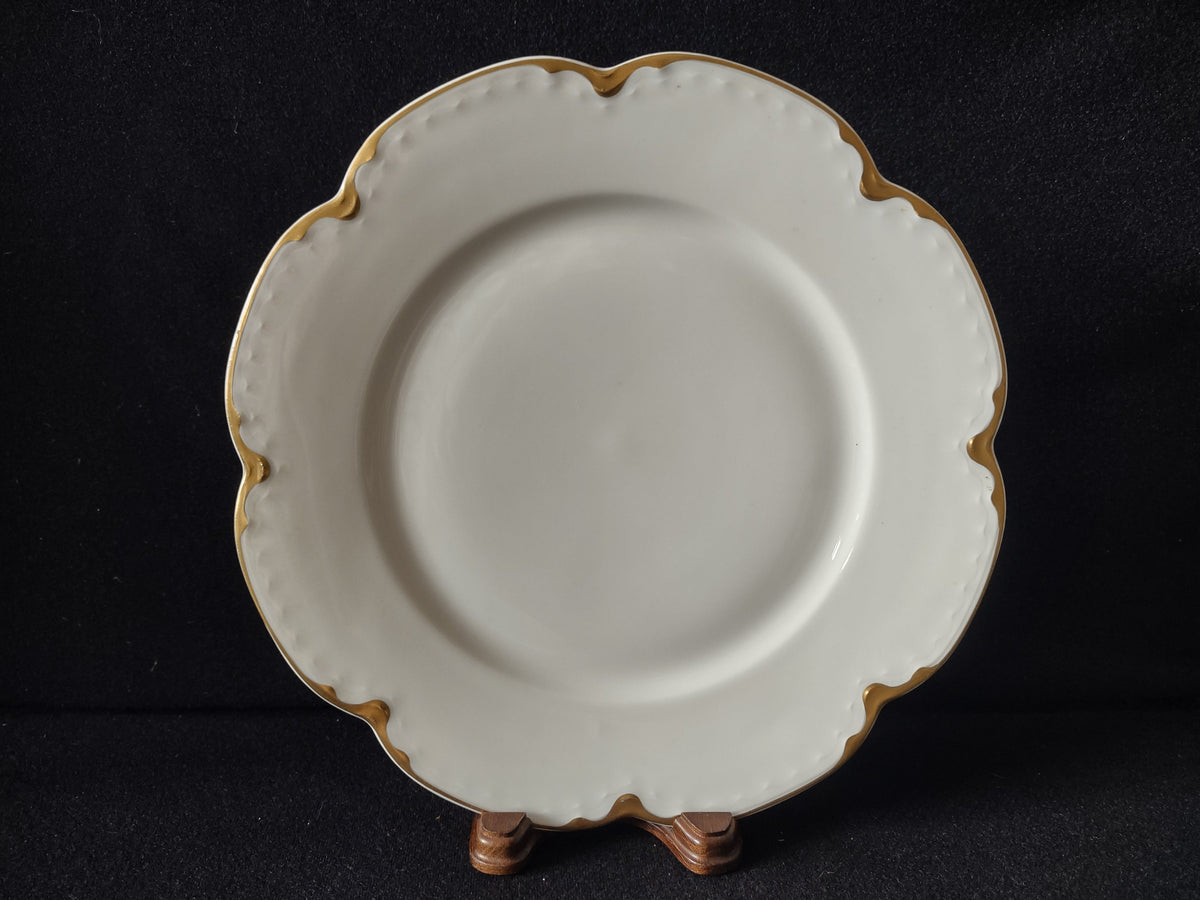 Close-up of scalloped edge showing heavy gold trim wear