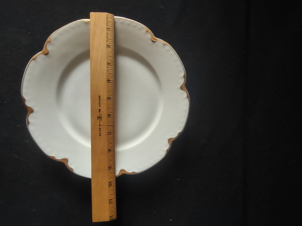 Back of vintage off-white scalloped porcelain plate showing base