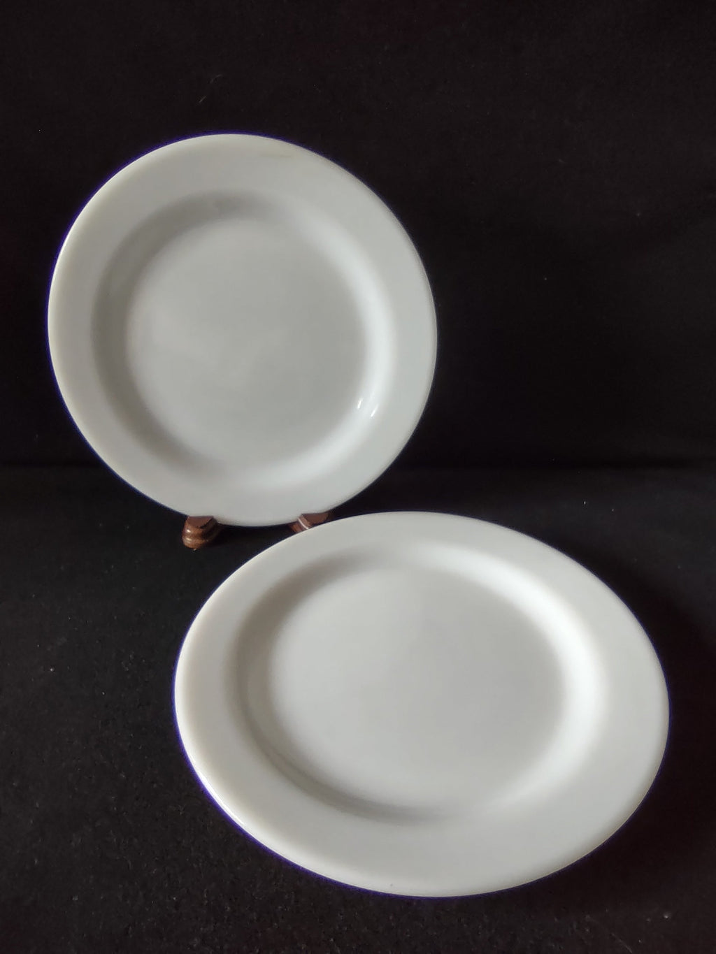 Close-up of white porcelain plate rim showing age discoloration on edge