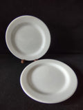 Close-up of white porcelain plate rim showing age discoloration on edge