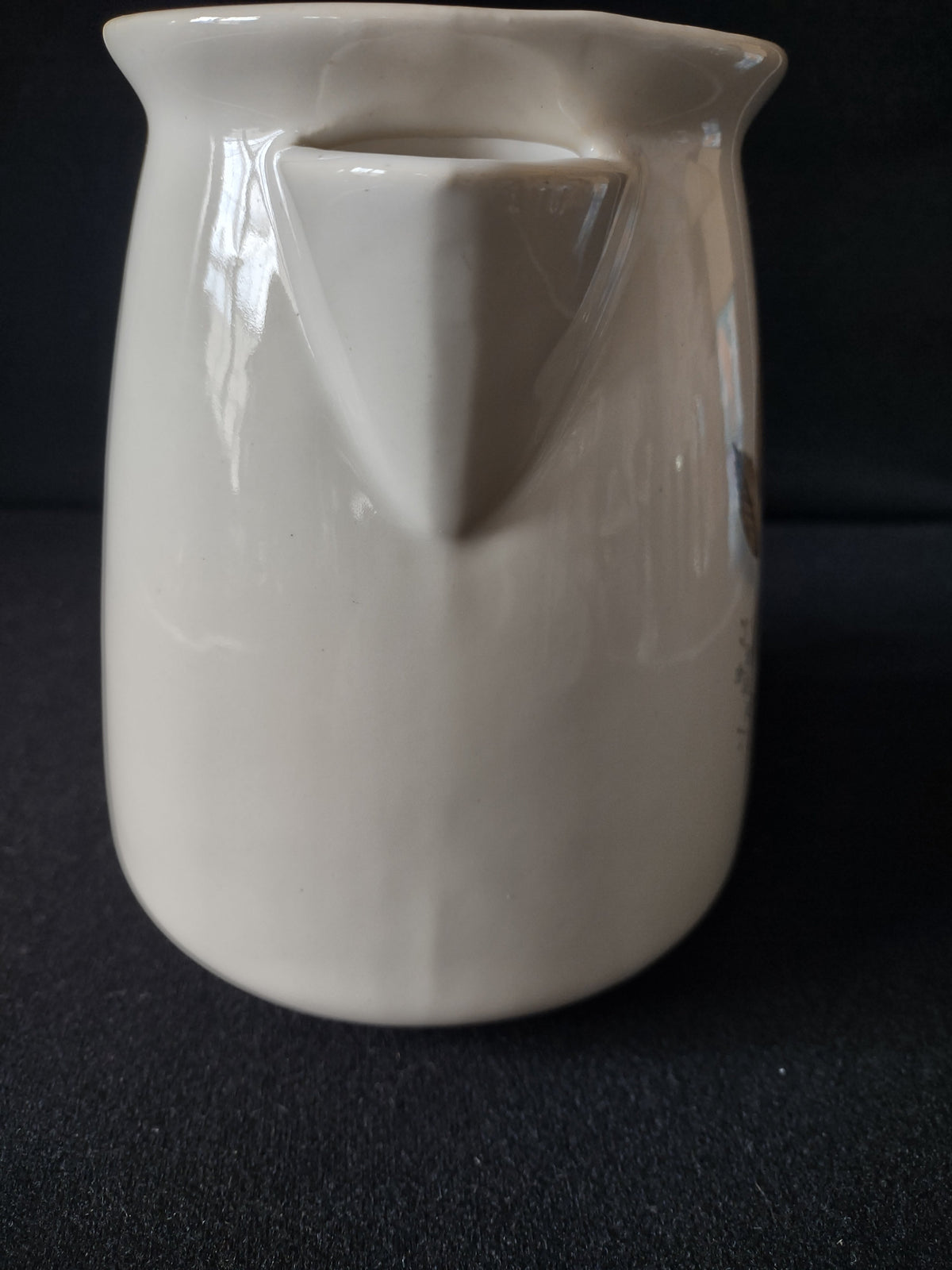 Back view of vintage ACv USA ceramic pitcher showing plain off-white glaze and spout
