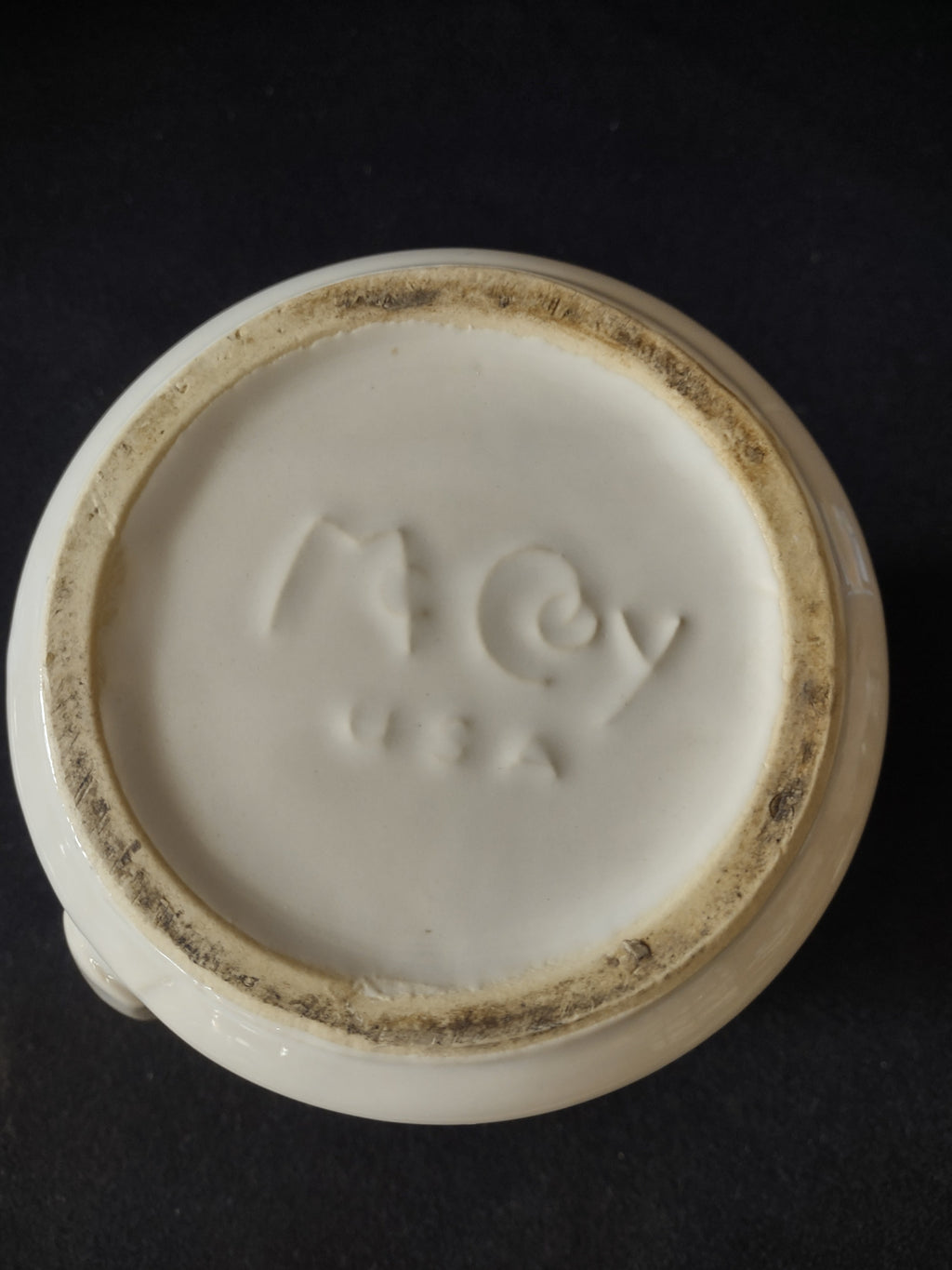 Bottom backstamp of vintage ACv USA ceramic pitcher showing embossed maker's mark