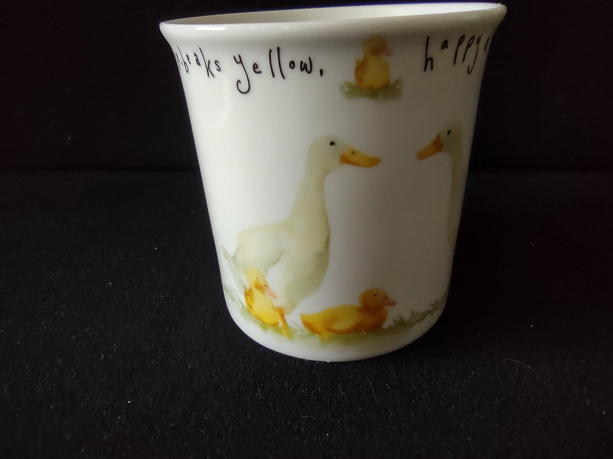 Front view: white ducks with yellow beaks, handwritten text around rim