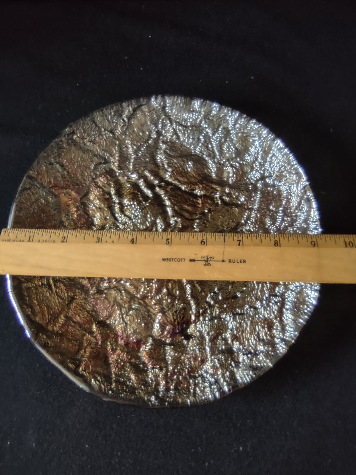 Close-up of heavily textured hammered bronze gold surface and rim