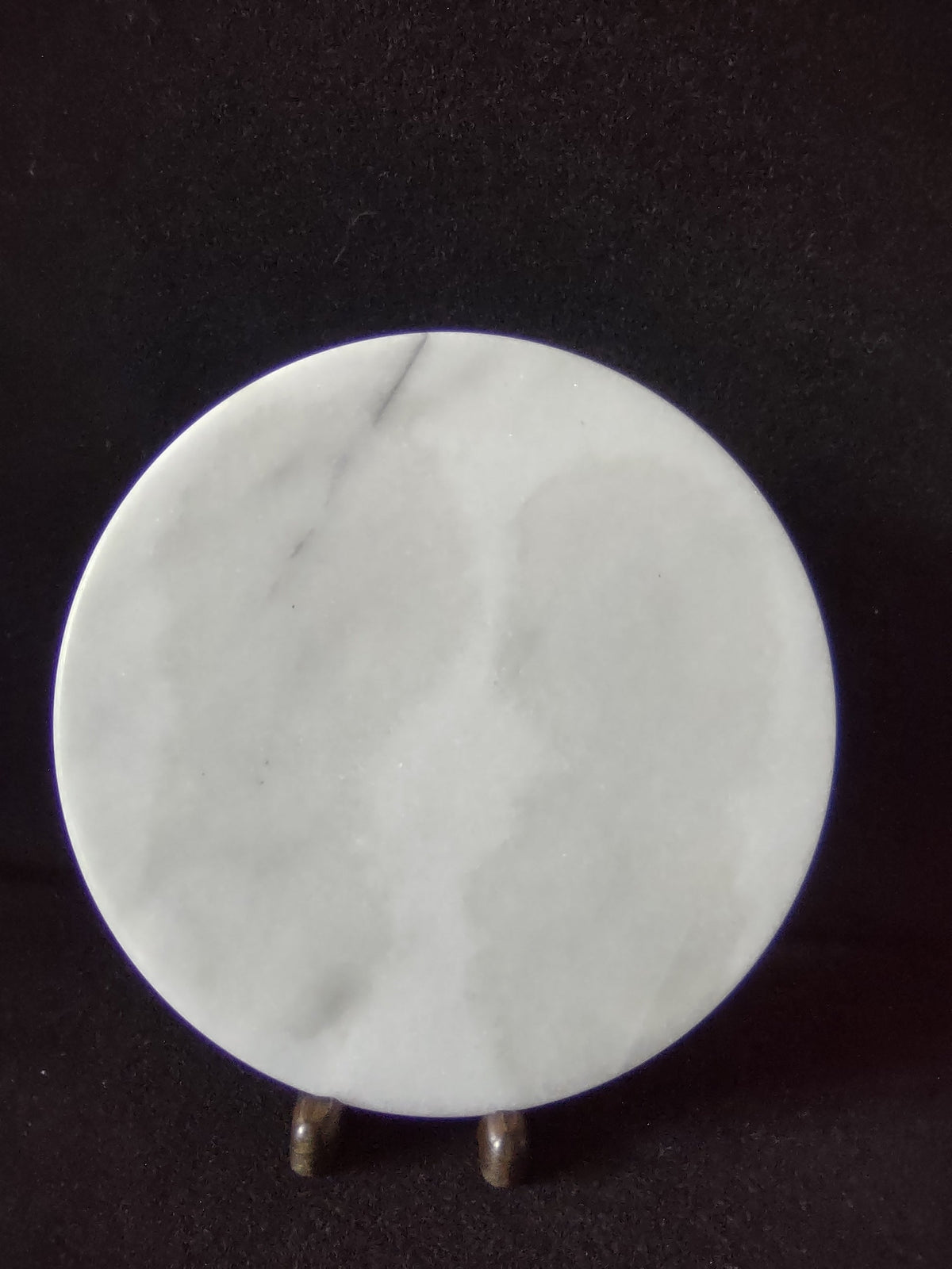 White marble round trivet serving board - front view on display stand