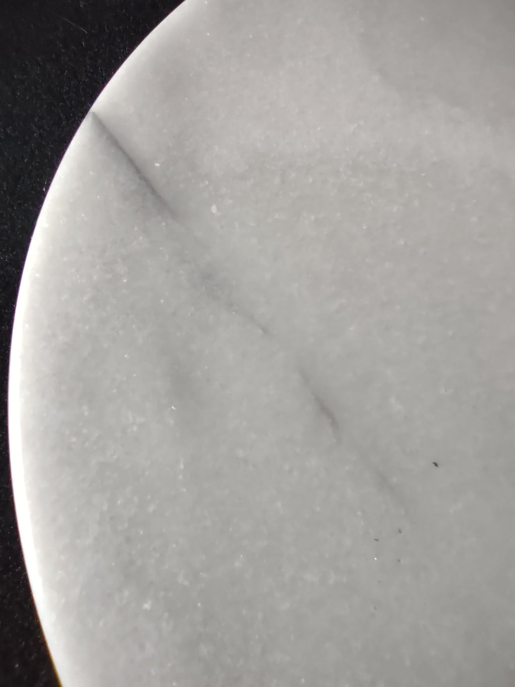 White marble round trivet serving board - close-up of grey veining on surface