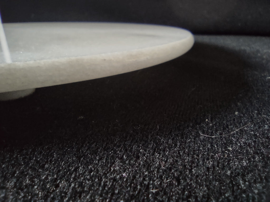 White marble round trivet serving board - edge profile showing thickness