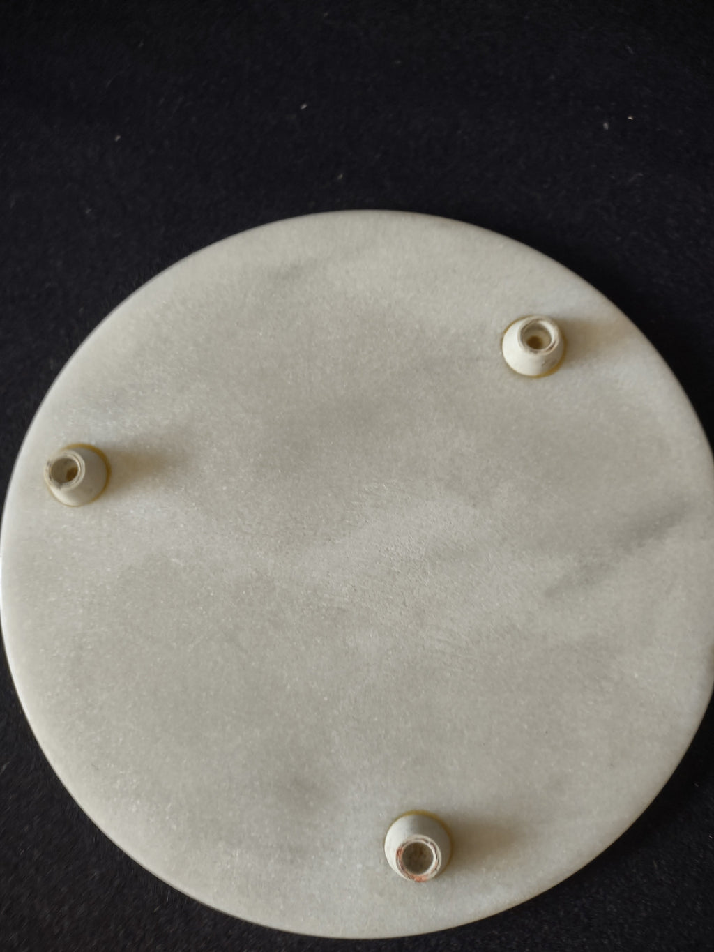 White marble round trivet serving board - underside showing three rubber feet