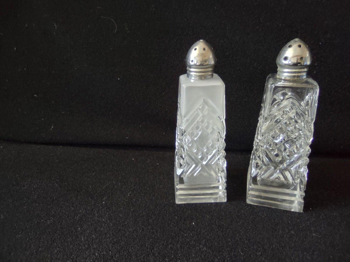Vintage mismatched pressed glass salt and pepper shakers with silver dome lids next to ruler showing approximately 4 inch height