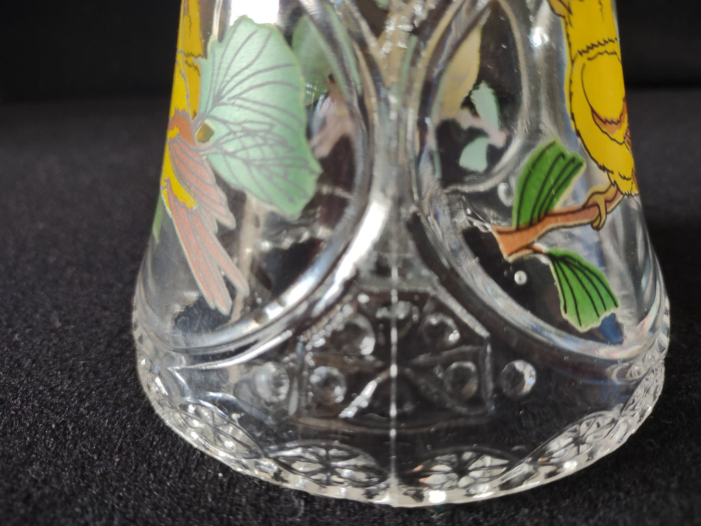 Close-up detail of yellow songbird enamel painting on crystal bell