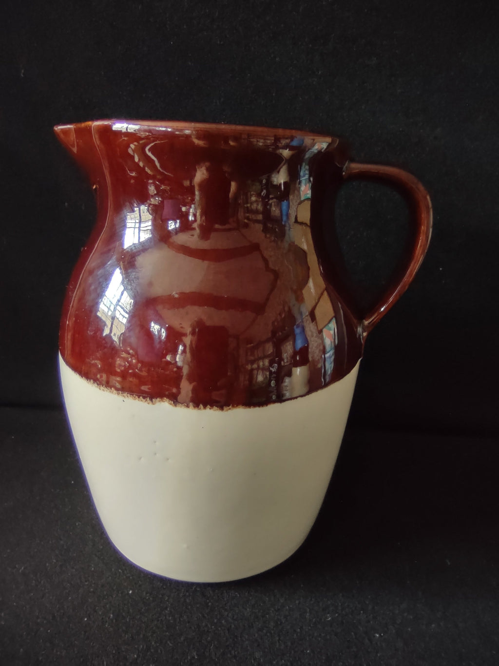 Vintage brown drip glaze stoneware pitcher, front view showing mahogany glaze over cream lower body