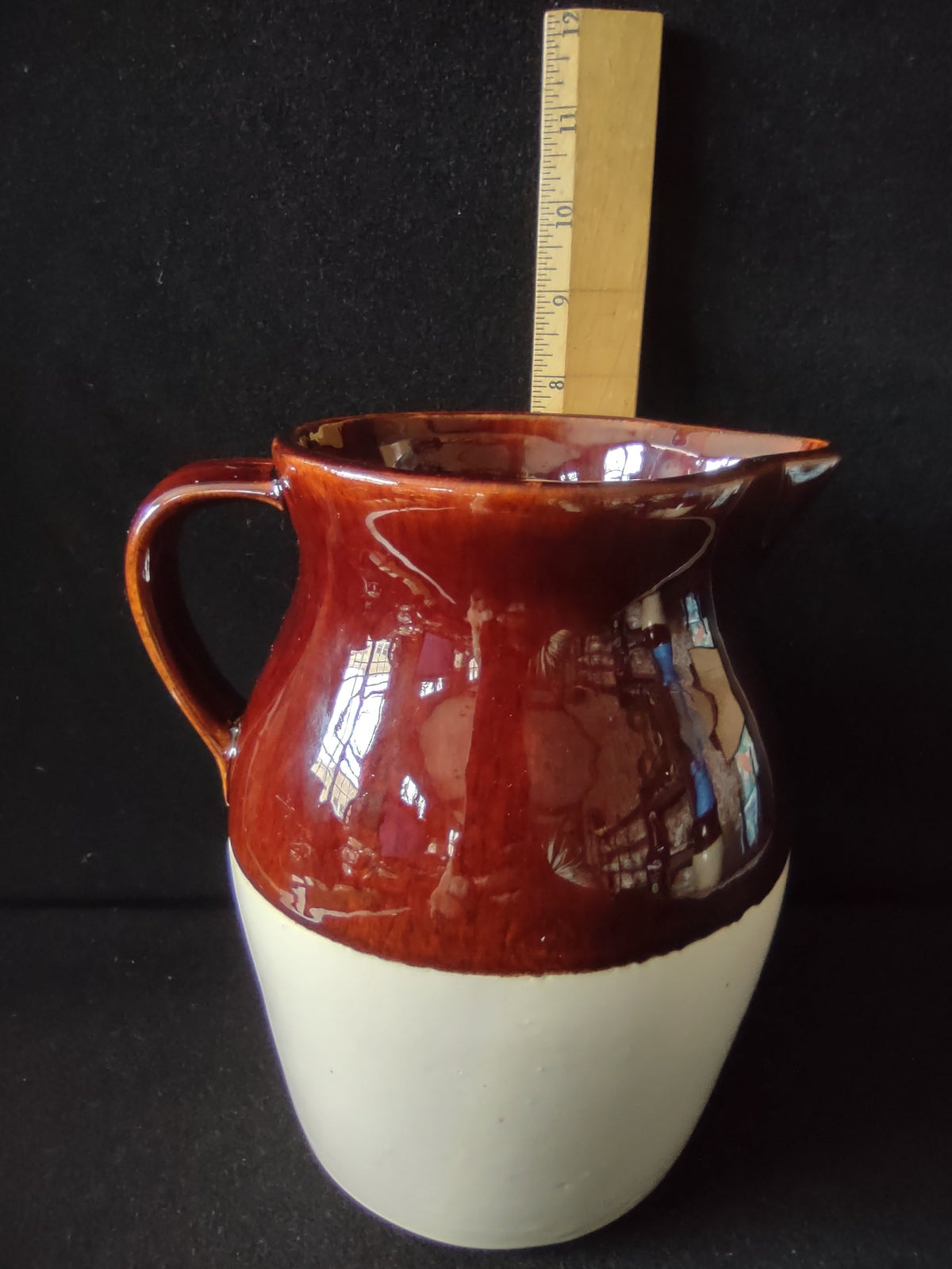 Interior bottom of stoneware pitcher showing maker's mark in script inside a circle