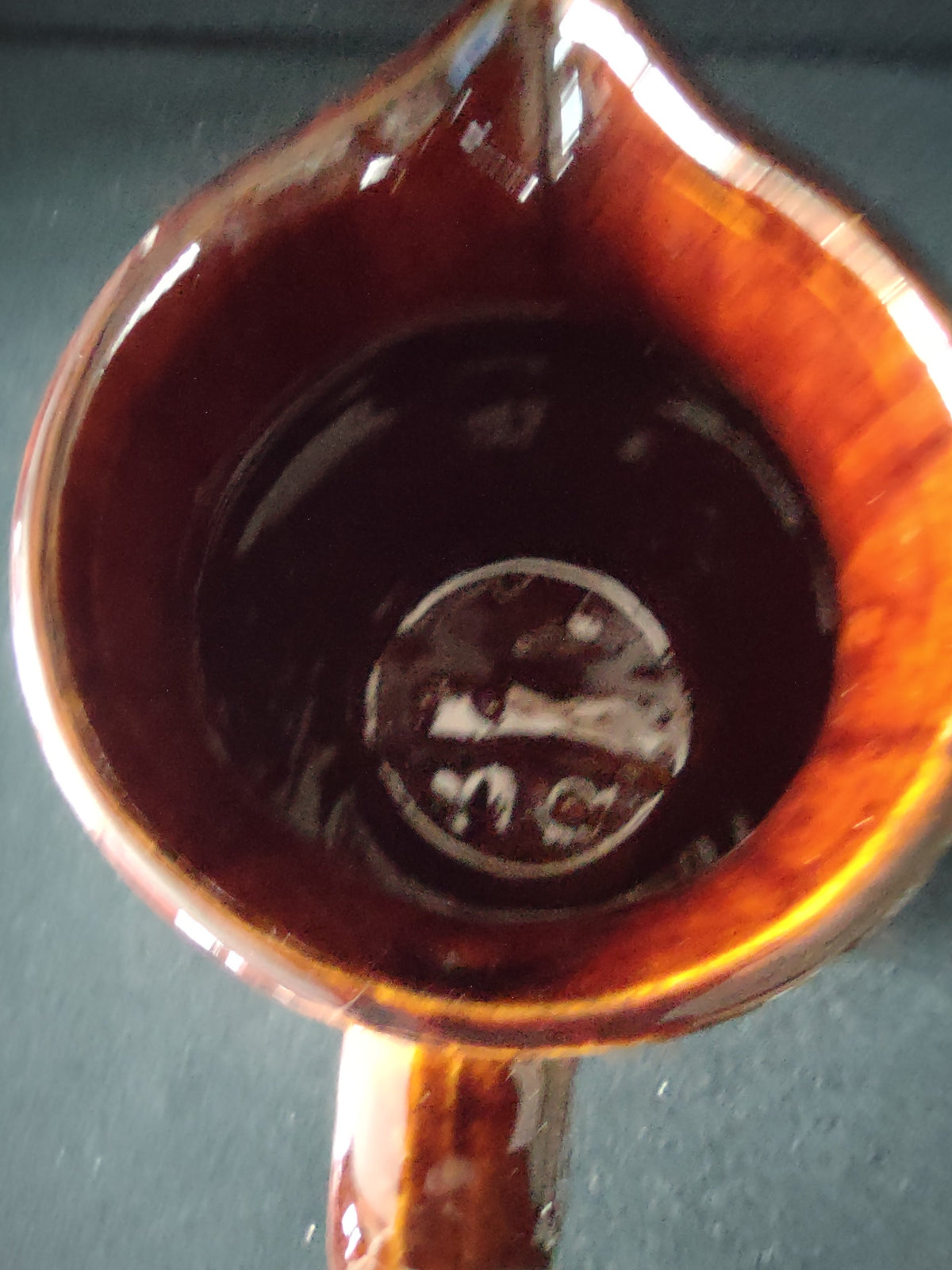 Back view of vintage stoneware pitcher showing two-tone brown and cream glaze