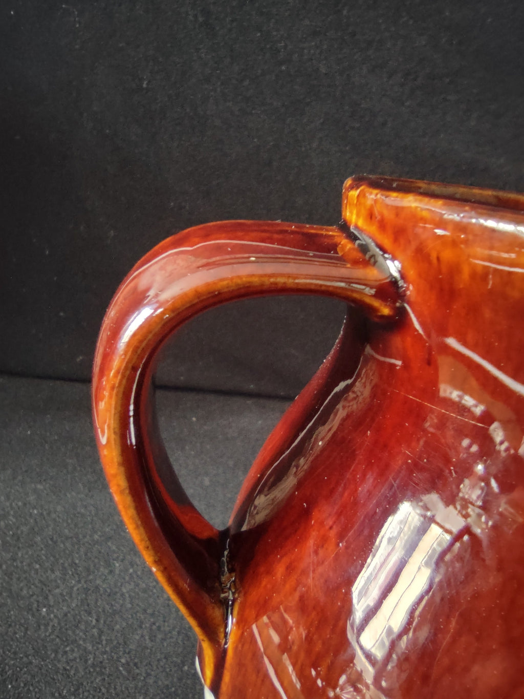 Close-up of handle attachment showing crack at top where handle meets rim