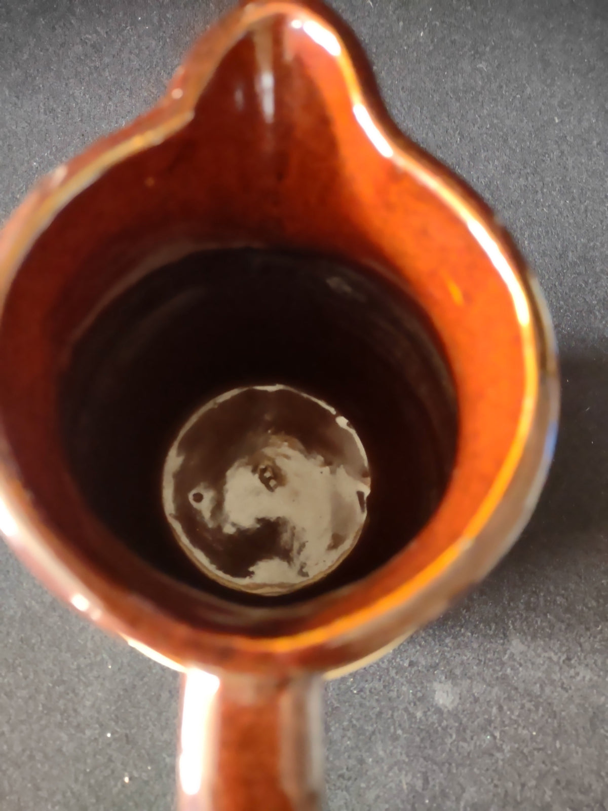 Additional angle of vintage stoneware pitcher showing handle and glaze transition