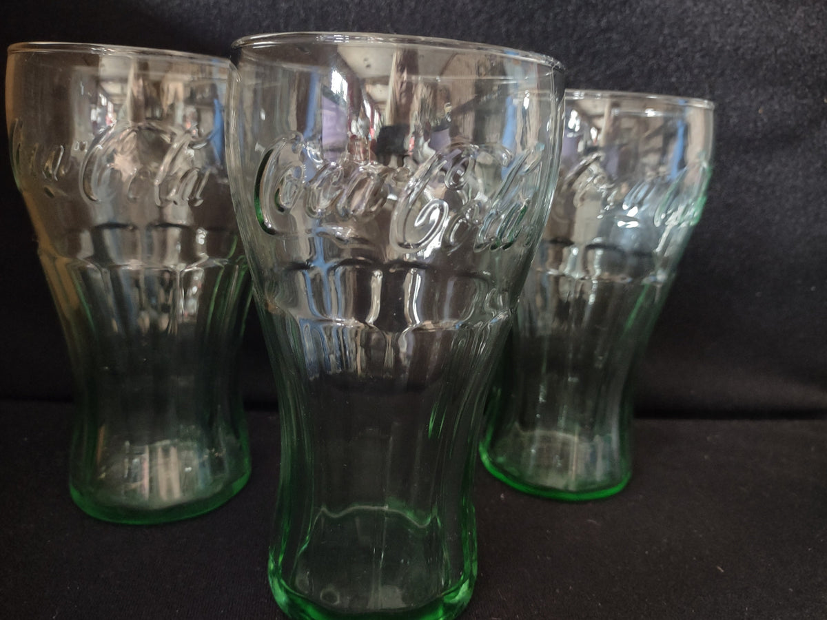 Close-up of Coca-Cola embossed script on green glass tumbler